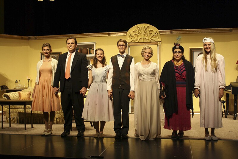 landscape photo of 7 student actors and actresses on stage wearing 1920s costumes and holding hands at the end of a play