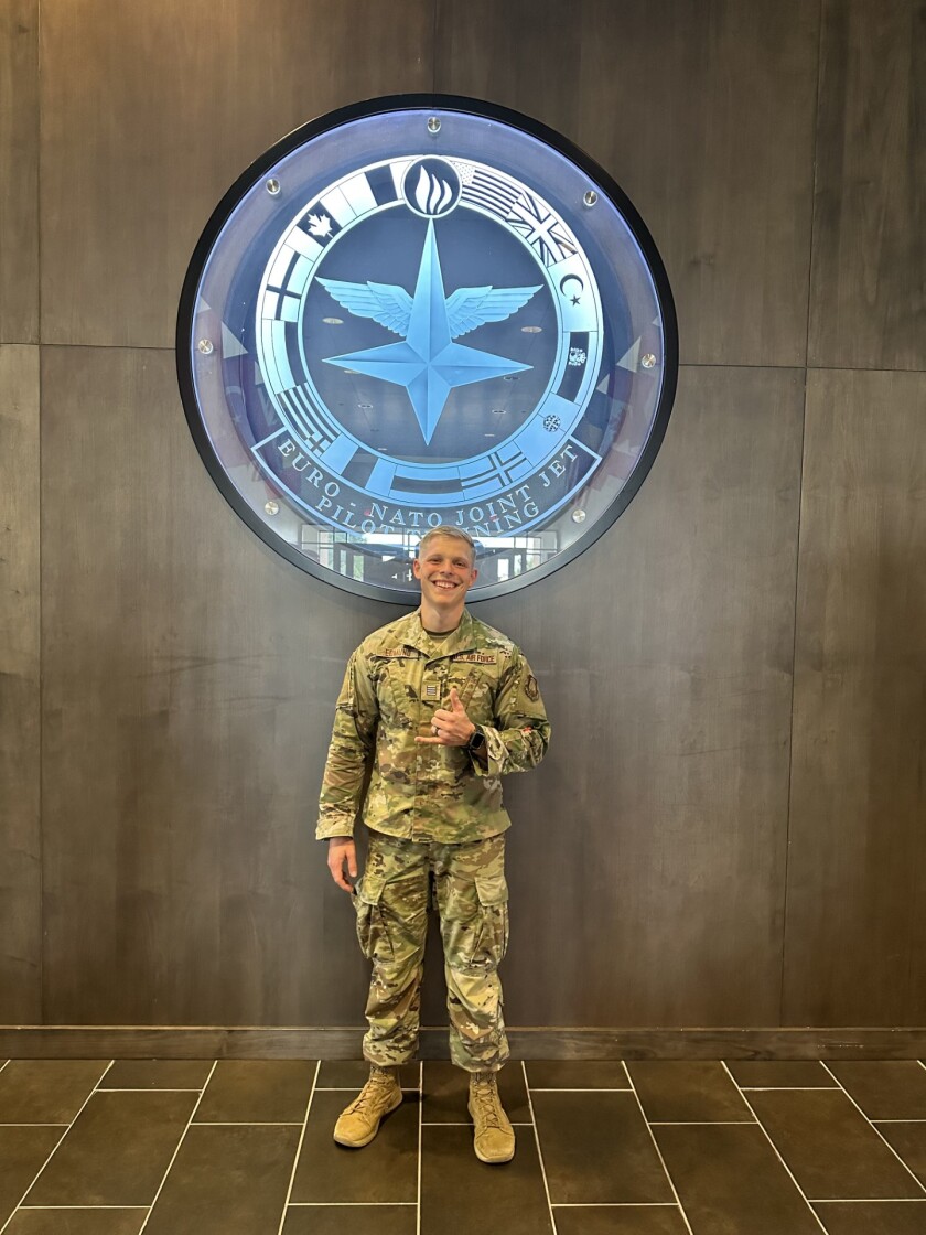 Photo of Edmund in front of a NATO sign.