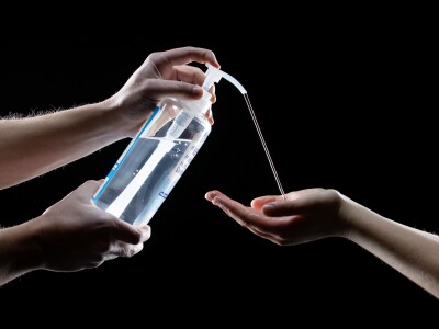 Hand sanitizer being squirted onto a hand.