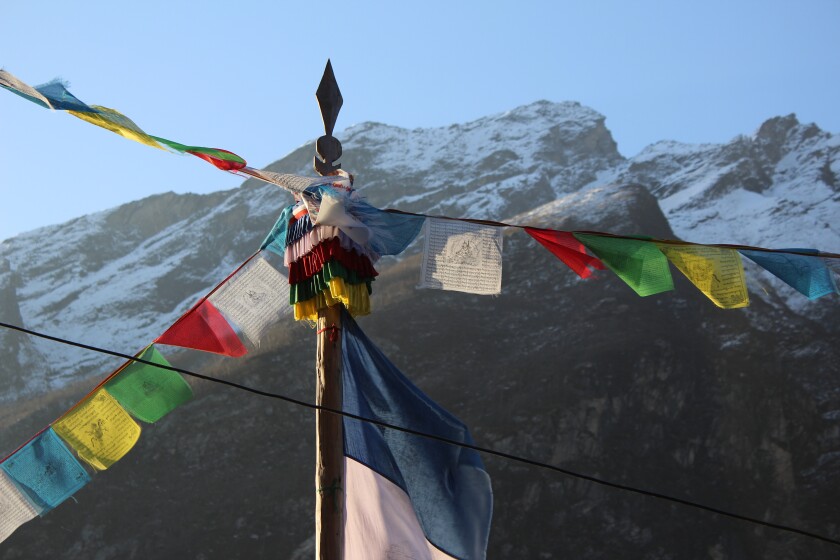 A photo of colored banners with a mountain in the background.