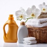 Wicker laundry basket with towels and white orchid flower, detergents and soap on white background.