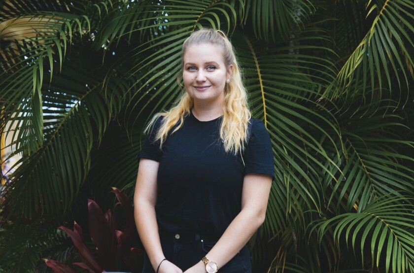 Rahel Meyer stands in front of foliage on campus.