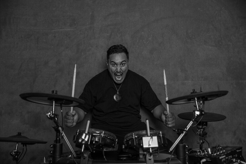 Man enthusiastically playing the drums.