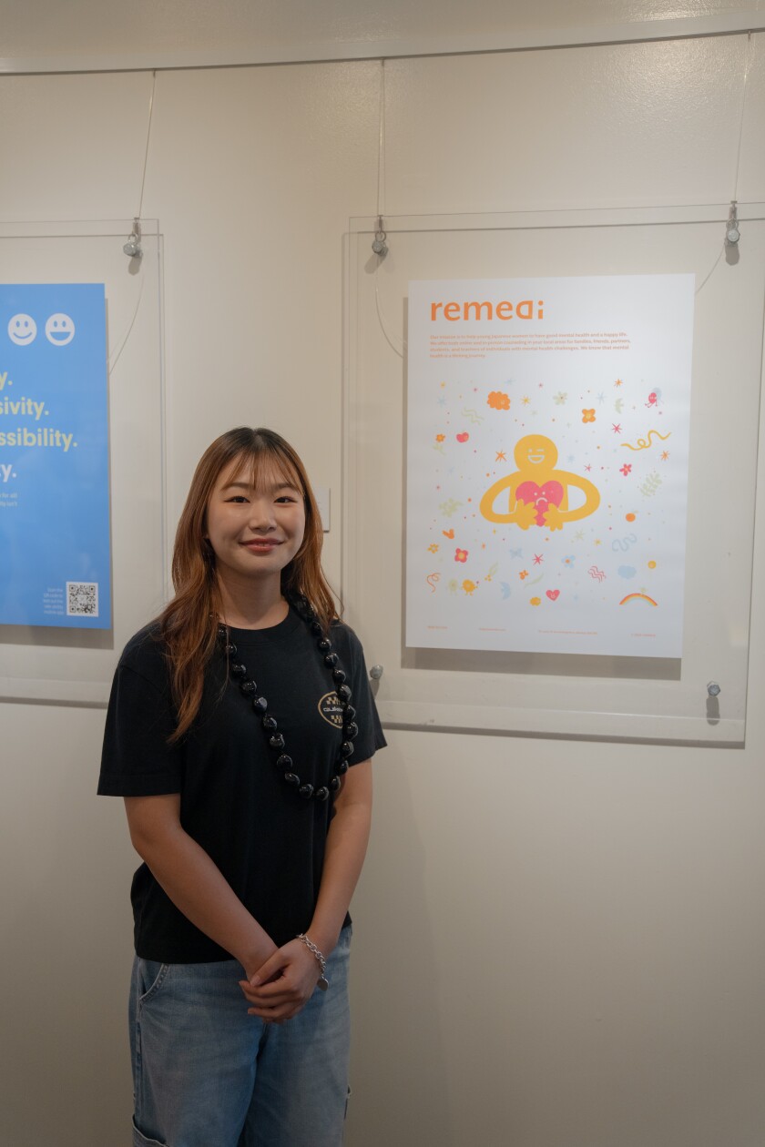A woman stands in a colorful poster with a graphic of a person holding a heart.