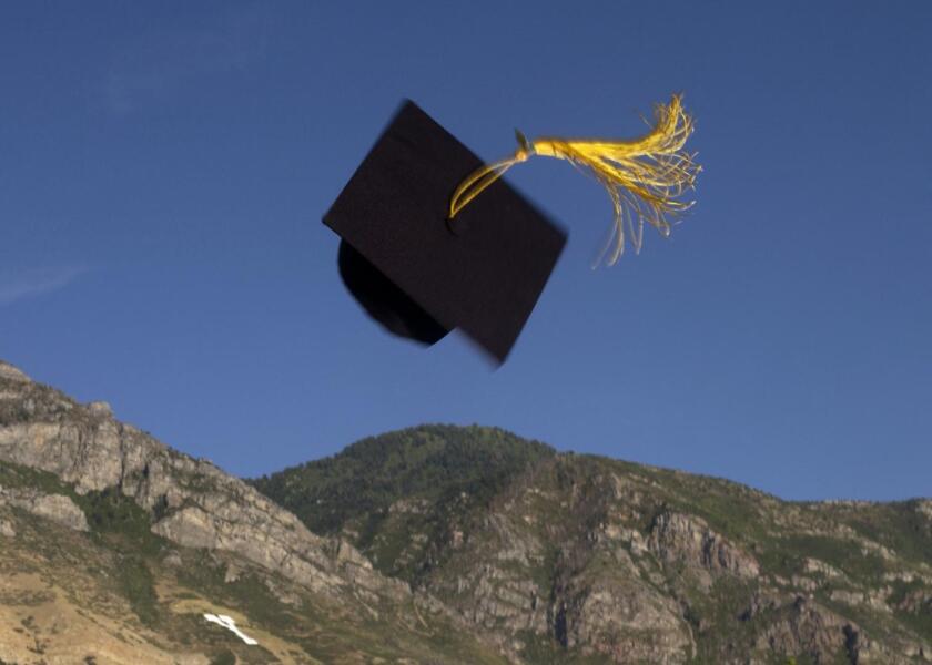 A Graduation cap thrown into the air in front of Y Mountain