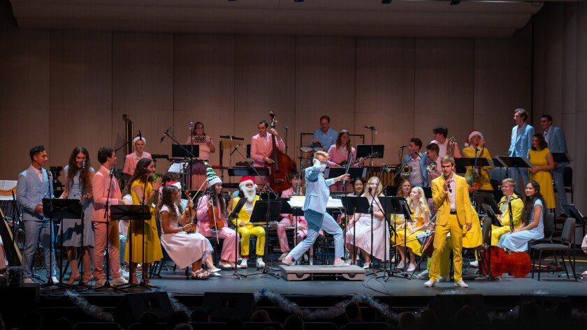 A guy singing while the orchestra is playing.