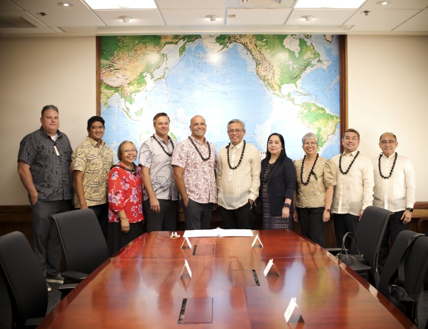 Persons standing in conference room.