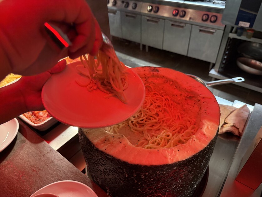 A wheel of parmigiana with pasta in the middle