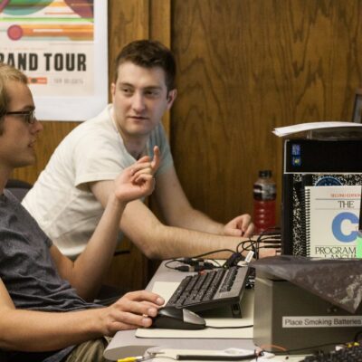 An image of two people sitting at a computer