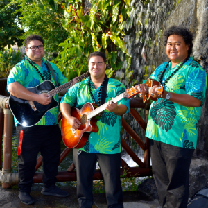 Three men in aloha attire holding guitar and ukulele