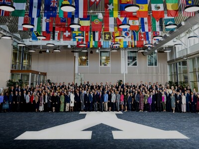 Group photo of delegates with world flags above them