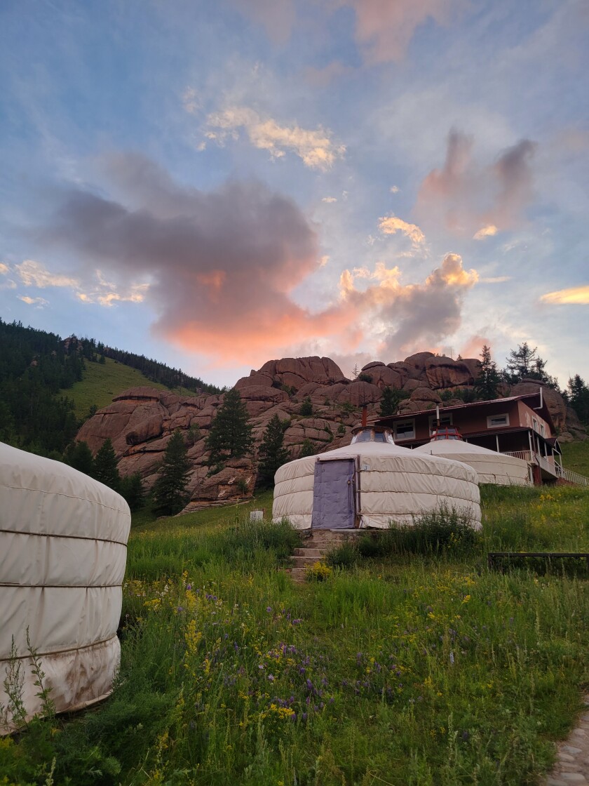 Yurts in Mongolia with a sunset in the background.