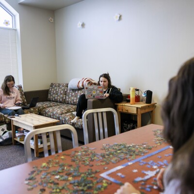 Students doing homework and building puzzle on living room at Heritage Halls