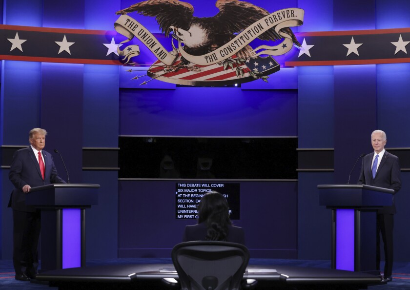Photo of Trump and Biden standing at their podiums with a blue walled background with an eagle at the beginning of the final presidential debate.