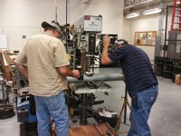 Physical Facilities employees cutting a pipe using proper safety equipment.