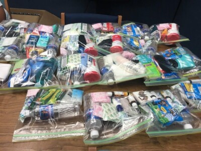 Plastic ziplock bags filled with toiletries and other items like water and chips.