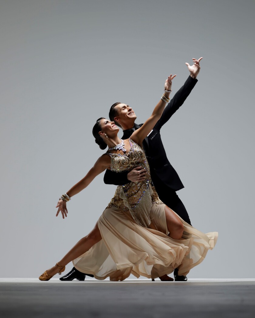 Two Ballroom Dancers lift their arms together, forming a strong line toward the right top corner of the image.