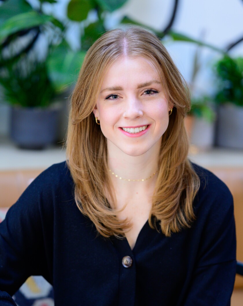 Kristen Hansen smiles in a headshot with plants in the background.