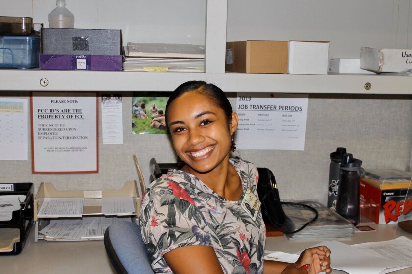Tamarina Barlow smiles as she sits in a chair in an office.