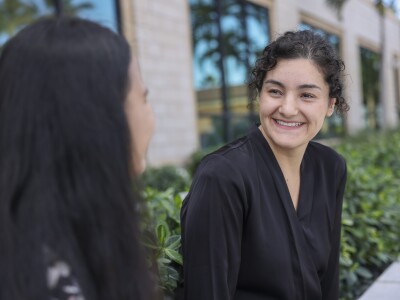 woman smiling at another woman in front of her