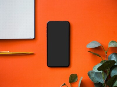 Image of a phone, pencil, and notepad on a desk