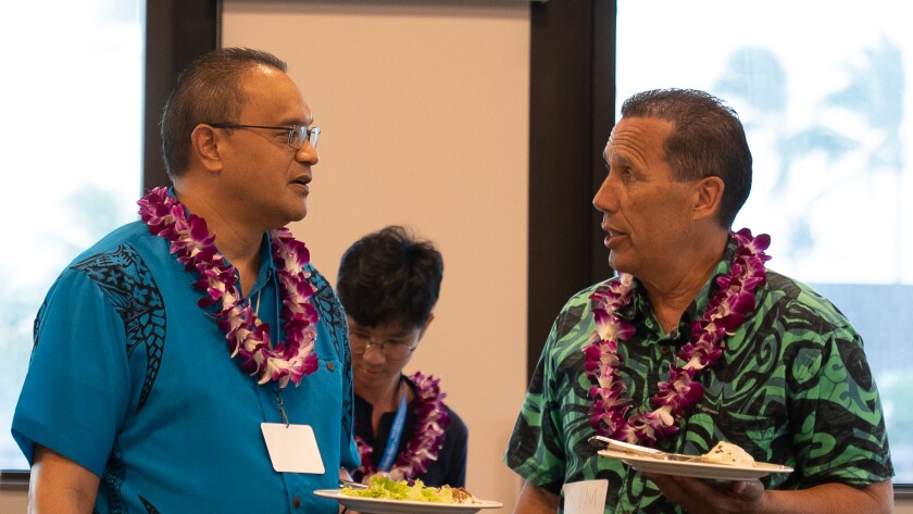 Professor Tevita Kaili and Polynesian Cultural Center Aotearoa Village Manager Kim Makekau both wear aloha shirts and purple and white orchid leis.
