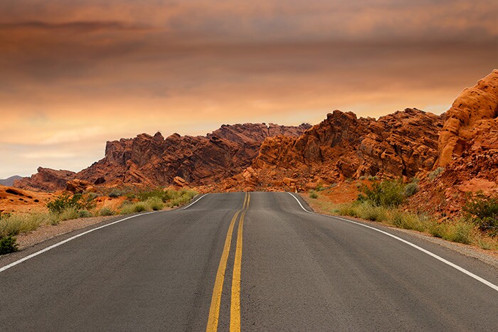 a road stretches toward rock formations