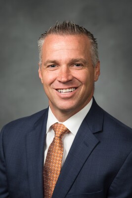 Shane Reese, professional headshot in front of a gray background