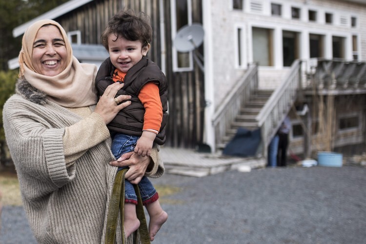 A Syrian refugee woman in Canada holding a young child
