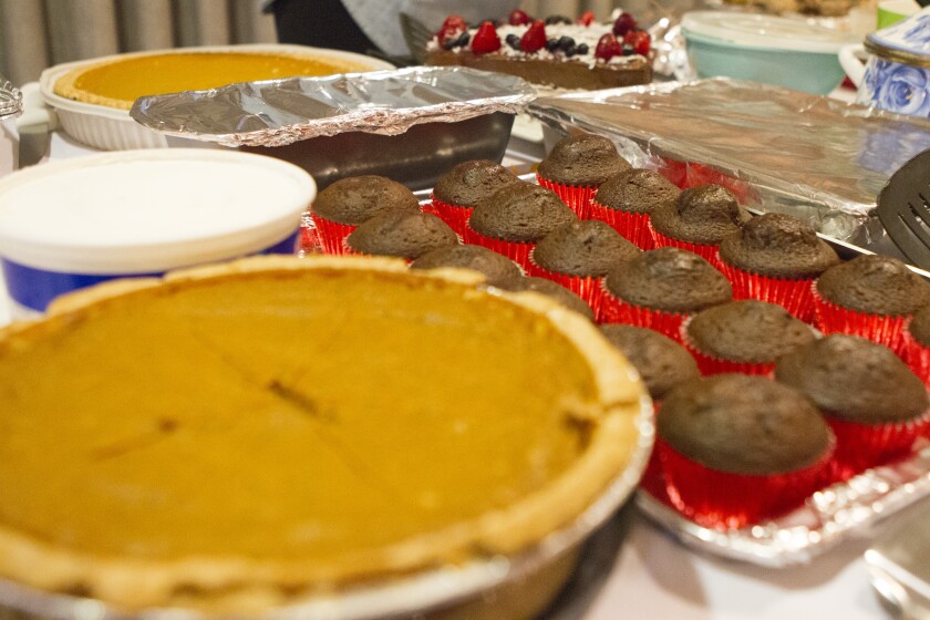 Thanksgiving desserts include pumpkin pie, cupcakes and cake with strawberries and blueberries on top.