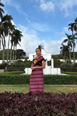 Azeni in a cultural attire posing in front of the Laie Temple
