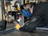Welder welding a metal frame.