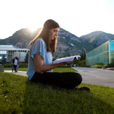 student reading on grass