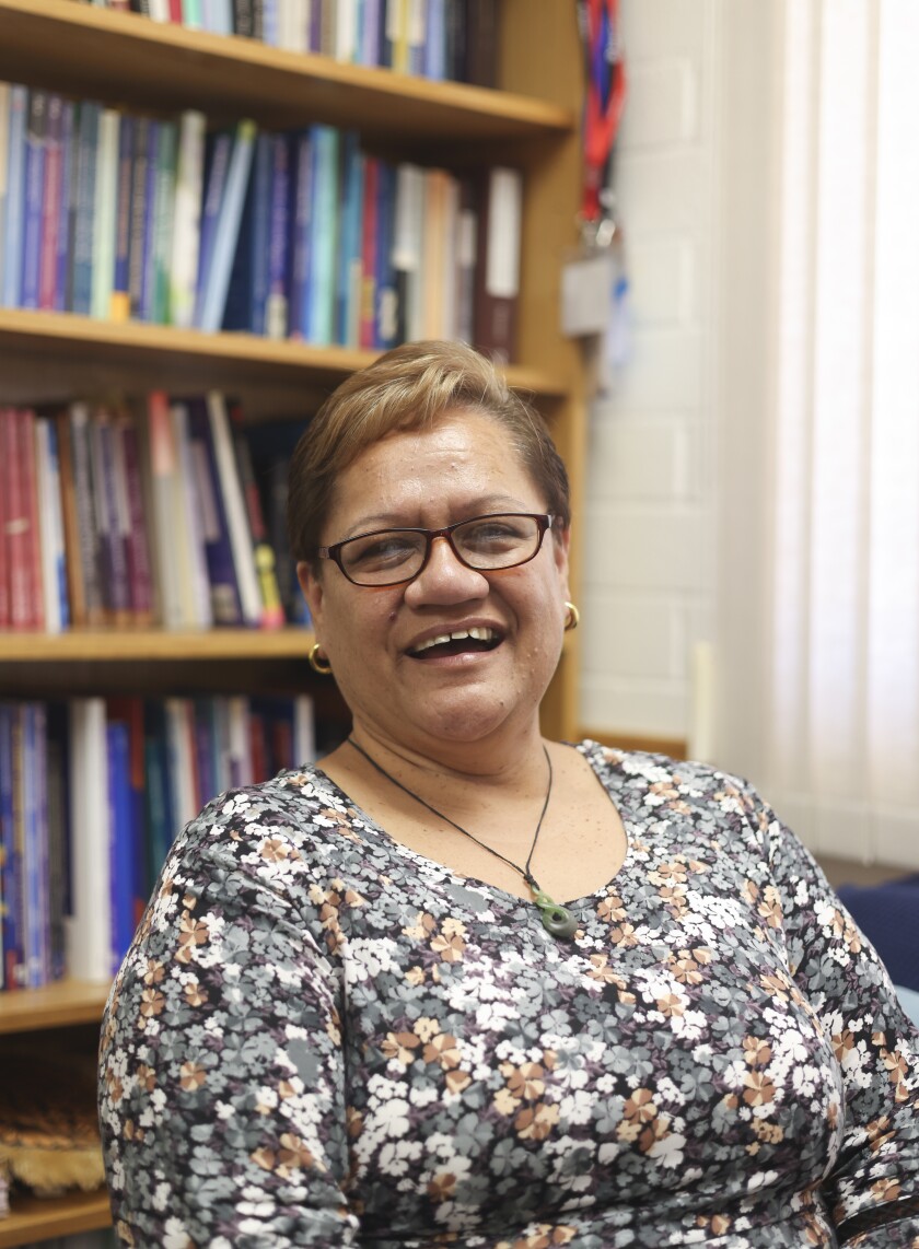 Nancy Tarawhiti sitting in her office in front of a book shelf.