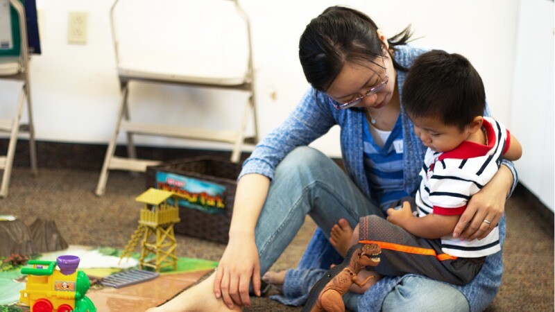 A young mom plays with her toddler son