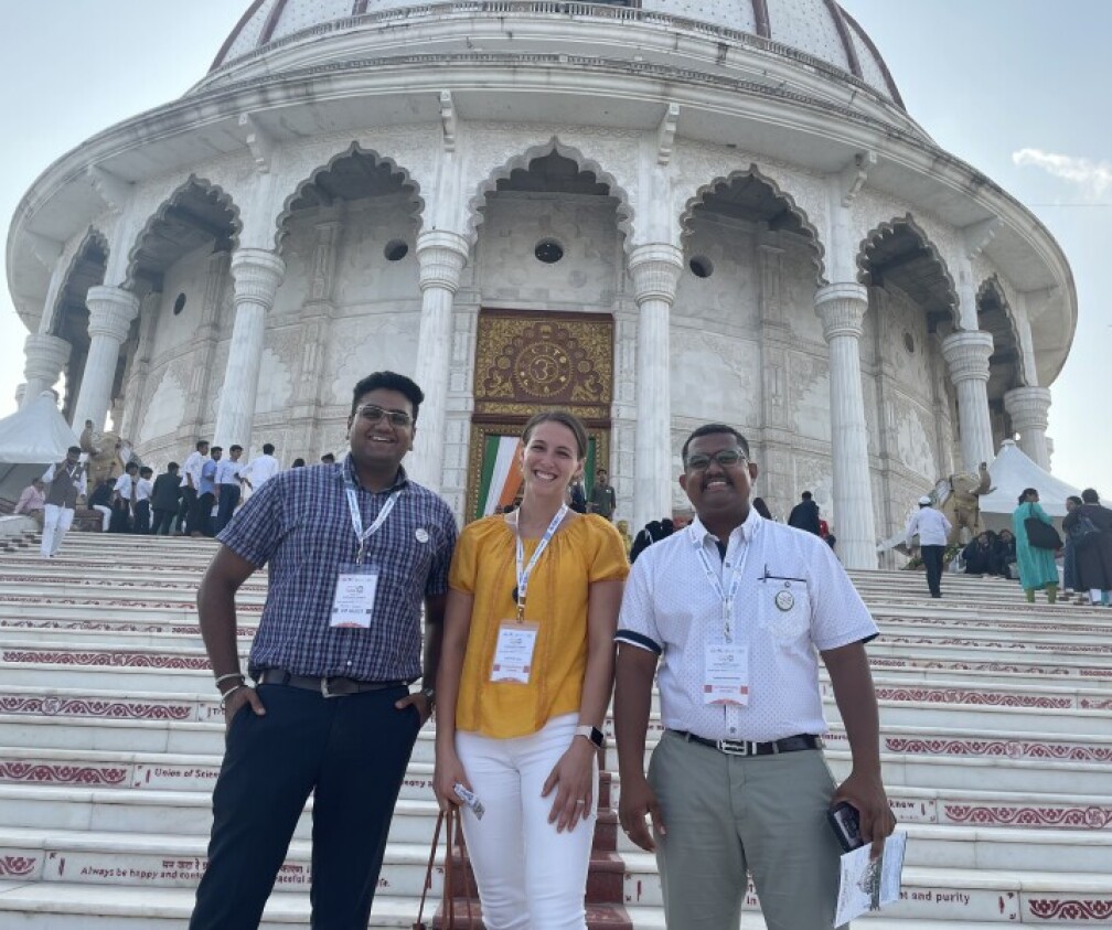 three people standing in front of Indian Temple