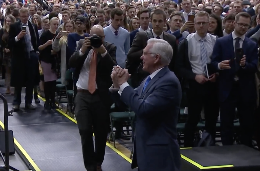 Elder D. Todd Christofferson grasps his hands together in gratitude as he thanks the choir members and those in attendance at the devotional.