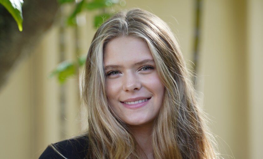 portrait shot of blonde female student wearing black shirt and smiling at the camera