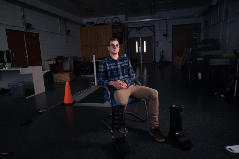 Seth Huber, a white male, sits next to a black spring-loaded boot.