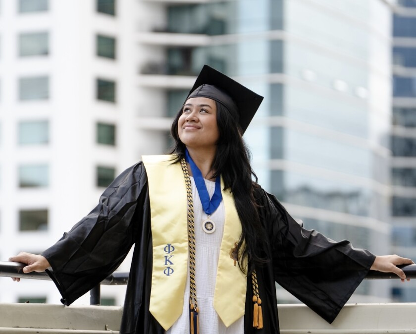 Rosalind Pedron in her graduate cap and gown looking up.