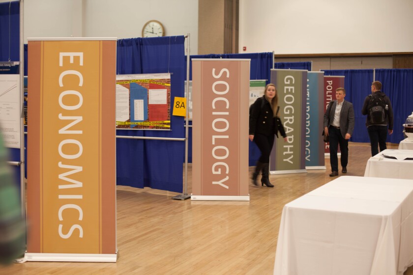 Students walk around the Mary L. Fulton Conference. Research is separated by topic. Photo credit: Austin Elliott