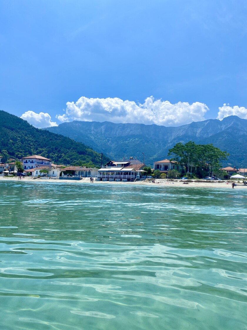 A coastline with huts framed by clear blue sky and turquoise water