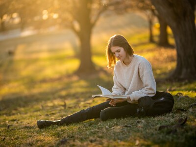 Girl student reading outside on campus