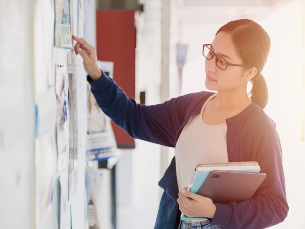 Person looking at posters on a bulletin board
