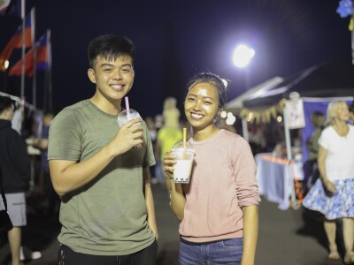 Two people drinking boba drinks.
