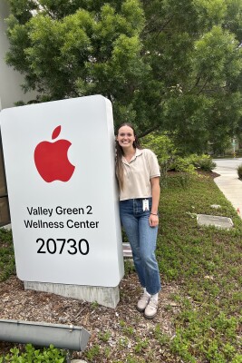 Woman stands next to Apple medical sign.