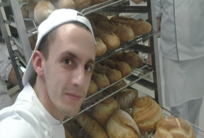 Wilhelm Ficquet stands in front of trays of bread