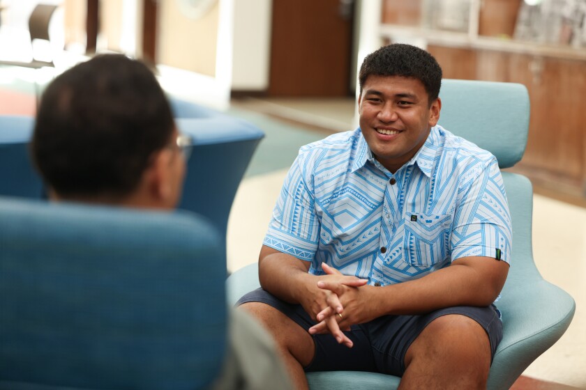 Kelvin Uili in a chair, talking to someone