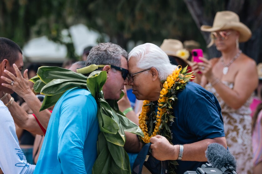 Cy Bridges (right) greets a man at the canoe festival Iosepa participated in at Kualoa Beach.