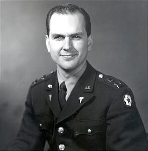 Black and white photo of Nelson smiling in his military uniform.